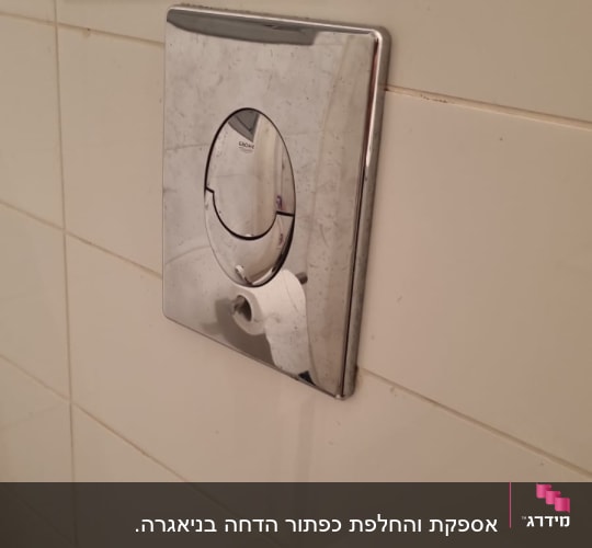 לחצן הדחה על קיר חדר אמבטיה
